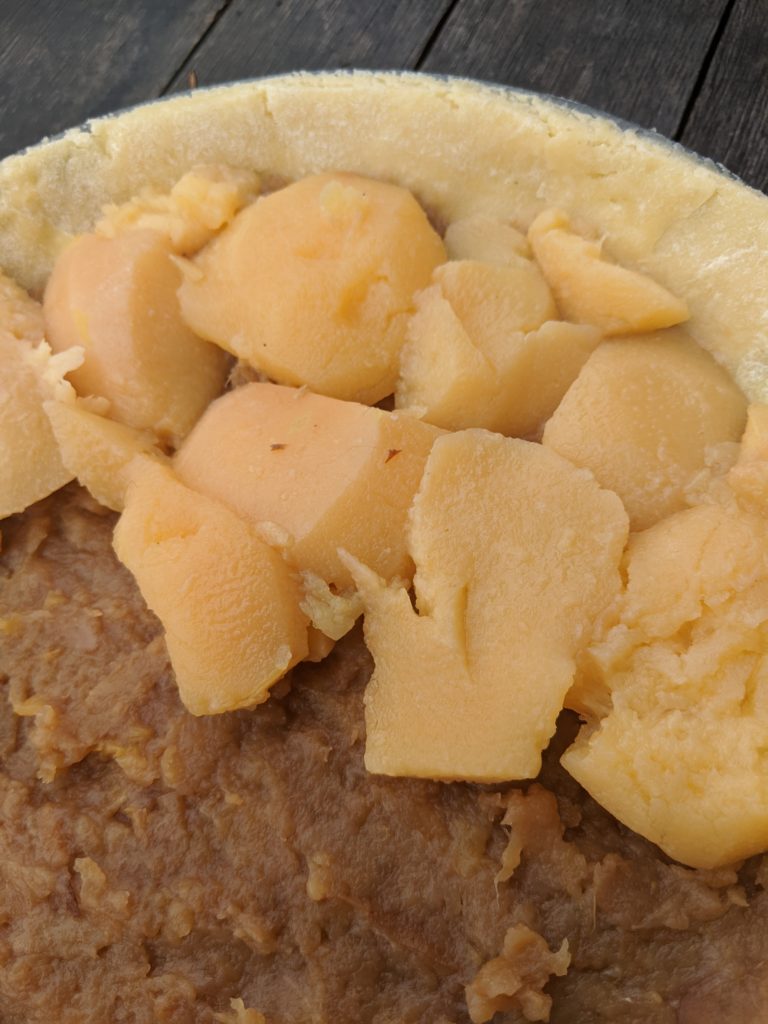 Close-up of poached quince pieces on top of a pie in preparation